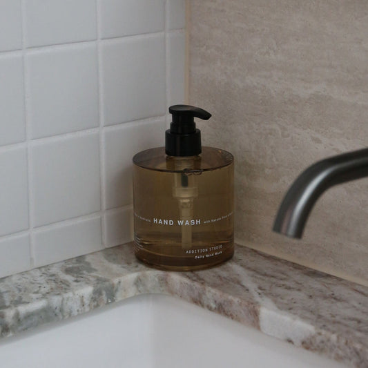 Addition Studio Hand Wash 390mL amber glass pump styled beside a bathroom sink