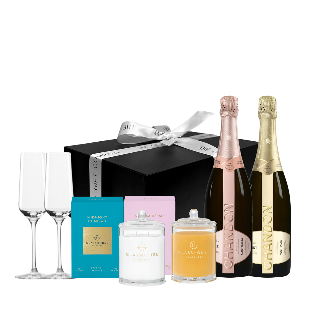 Gift set with champagne bottles, glasses, and other items on a white background