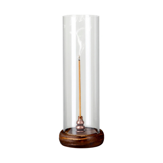 Incense stick in a glass cylinder with wooden base on a white background