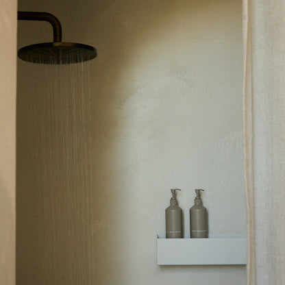Addition Studio Body Liquid Exfoliator displayed beside Body Wash in shower setting