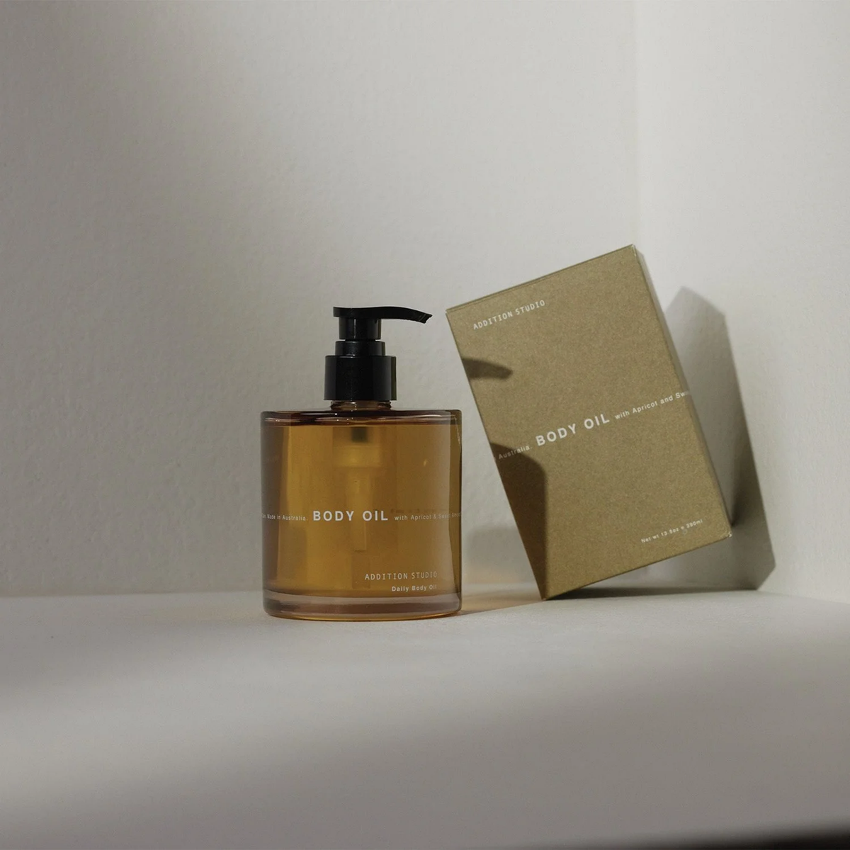 Addition Studio Body Oil 390mL real bottle beside the correct kraft packaging