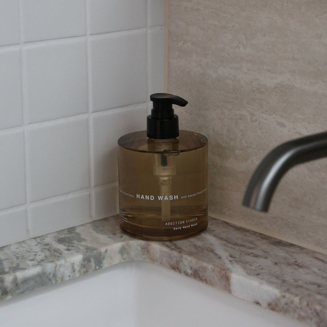 Addition Studio Hand Wash 390mL amber glass pump styled beside a bathroom sink