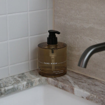 Addition Studio Hand Wash 390mL amber glass pump styled beside a bathroom sink